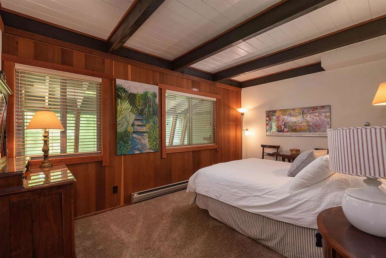 Lower-level master bedroom with queen bed and pine forest views in the Olympic Valley ski cabin near Palisades Tahoe