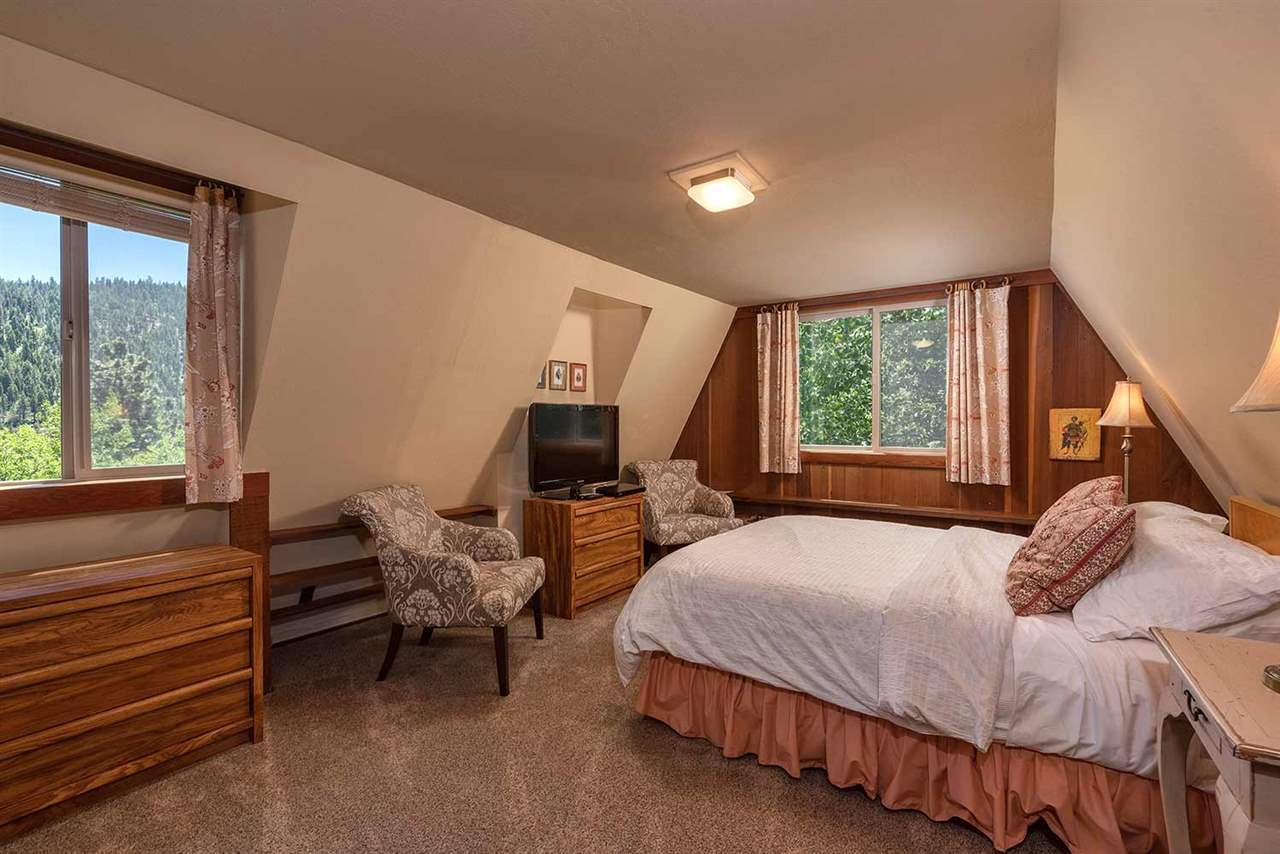 Bright primary bedroom with king bed and forest views in the 4-bedroom Lake Tahoe ski cabin
